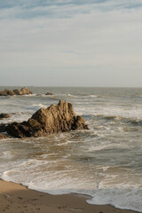 Sandy beach with coastal rocks in the water
