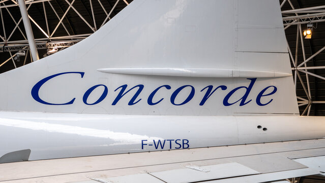 Close-up of an airplane tail with a Concorde logo in a hangar