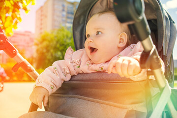 Baby Sitting in Stroller Outside. A baby is comfortably seated in a stroller outdoors. The infant...