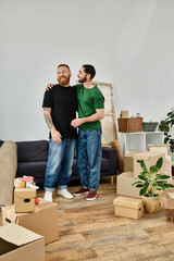 A gay couple in love, surrounded by moving boxes, standing together in their new living room.