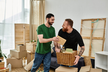 Two men, a gay couple in love, stand side by side in a room surrounded by boxes, starting a new life in their new home.