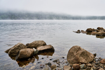 Boulders on the shore of Vernon lake in the early morning