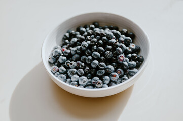 Fresh blueberries in a bowl on a white table