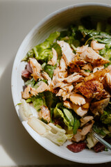 Bowl of fresh greens with grilled salmon, a summer salad