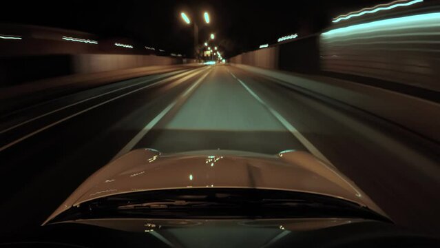 Hyperlapse footage from a car while driving in the city at night showing lights and empty roads