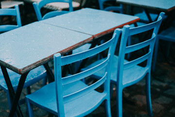 some blue chairs a brown table and some plants in a window