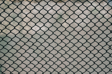 a tennis ball in the cage, with clouds behind it