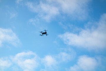 Small drone flying in the blue sky