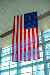 an american flag hangs in the middle of an atrium area