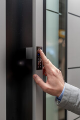 Vertical closeup shot of a person using an electronic door pad to enter an apartment
