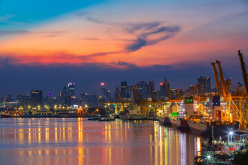 Cityscape at view evening sunlight from the river cargo container import container ship in the international terminal logistic seaport concept freight