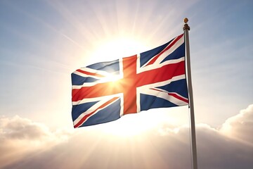 British flag against sky and sunlight background. The national flag of the United Kingdom on a pole.