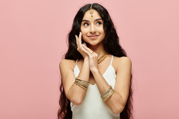 Beautiful indian woman striking a pose against a vibrant pink backdrop.