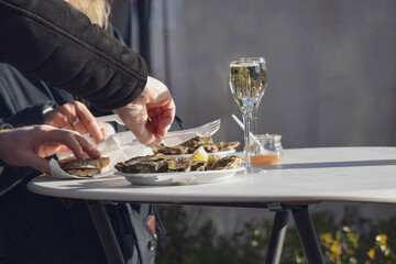 Woman eating fresh oysters at Christmas market in Paris
