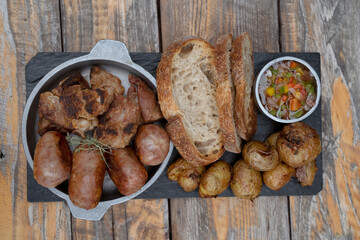 Barbecue. Traditional asado criollo plate. Top view of chorizos, pork sausages, grilled sweetbreads, potatoes and bread.