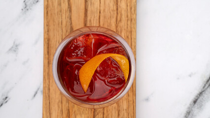 Drinks. Top view of a Negroni cocktail with gin, campari, red vermouth, ice and orange peel in a glass.