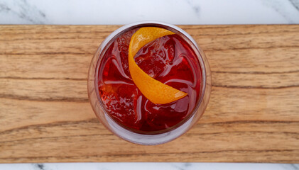 Drinks. Top view of a Negroni cocktail with gin, campari, red vermouth, ice and orange peel in a glass.	

