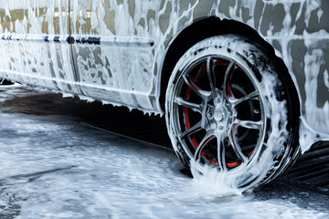 Close up car in foam. Car getting a wash with soap, car washing.