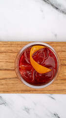 Drinks. Top view of a Negroni cocktail with gin, campari, red vermouth, ice and orange peel in a glass.	