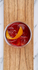 Drinks. Top view of a Negroni cocktail with gin, campari, red vermouth, ice and orange peel in a glass.	