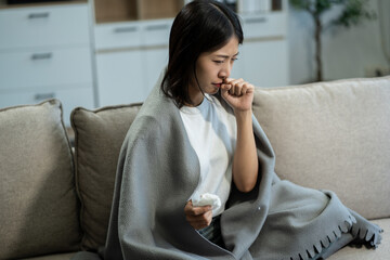 Young woman holding medicine and glass of water, feeling sick, health care concept.