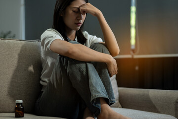Sad and depressed young female sitting on the sofa, sad mood, feel tired, lonely and unhappy...