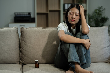 Obraz premium Sad and depressed young female sitting on the sofa, sad mood, feel tired, lonely and unhappy concept.