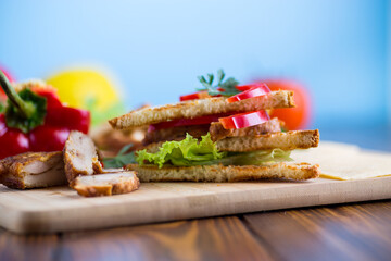 fried toast with chicken, salad, greens on a wooden table