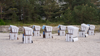 Very beautiful view of the sandy beach of the Baltic Sea. There are traditional German sun loungers with a hood on the white sand. (Strandkorb). Germany, Usedom