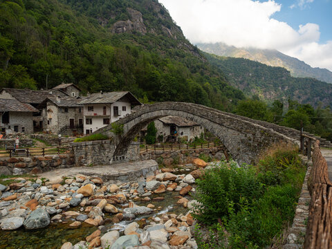 Old medieval stone bridge in the small mountain village of Fondo in Valchiusella valley, northern Italy