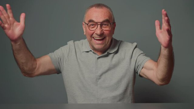Funny nice glad impressed man unbelievable victory at grey background