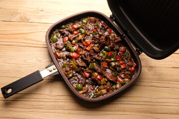 closeup of black pepper beef. cooked with black pepper, red and green peppers, onions, oyster sauce, pepper and spices. in fry pan.