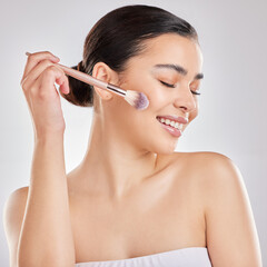 Fototapeta premium Woman, makeup brush and smile in studio for blush, cosmetics and application on white background. Female person, beauty and tools with happiness for highlight, contour and skincare with eyes closed