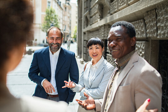 Group of businesspeople walking and talking in the city