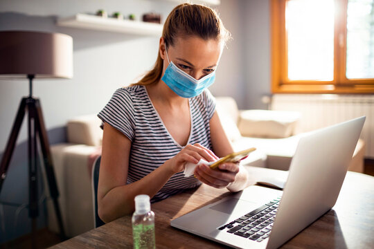 Woman cleaning smartphone screen with disinfecting wipe