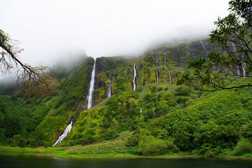 Cascata da Ribeira do Ferreiro, Flores Island, Azores, Portugal. Long exposure waterfalls. Waterfall with  tropical green vegetation and forests. Travel destination. Hiking on Azores Islands.