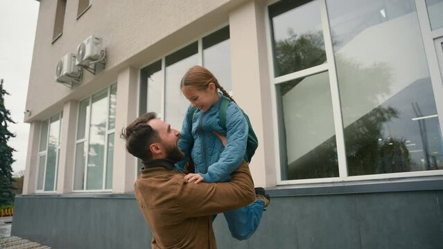 Daughter run to father hug lift pick up happy family meeting child offspring little girl schoolgirl elementary school kid educational study support parenthood relations enjoying embrace cuddle care