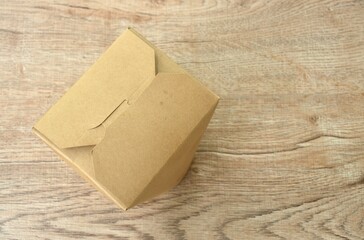 noodles packaged in hard brown paper box for take home on table