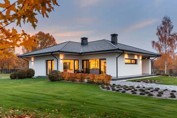 Minimalist Zen style white family house with black flat roof, and beautiful front yard with lawn in autumn
