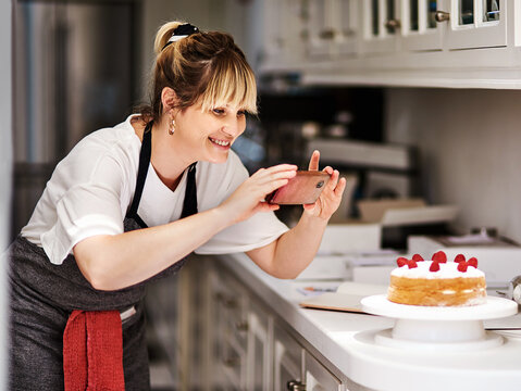 Picture, cooking or woman with mobile for social media, recipe or meal ingredients in house kitchen. Cake photography, chef or happy baker with phone for content creation, food menu or live streaming