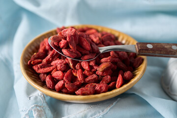 Dried goji berries on bowls and spoon, fruit from china and tibet