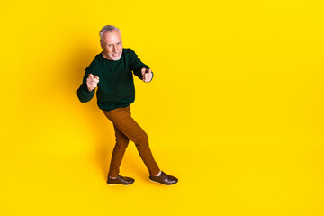 Full size photo of nice senior man point you gesture dressed stylish green clothes isolated on yellow color background