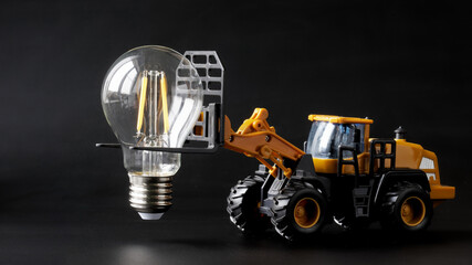 Lighting installation.Toy tractor transports and prepares to install an LED electric lamp. ...