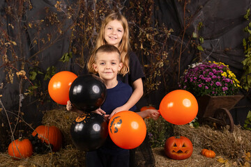 close-up portrait of happy, funny children holding a pumpkin on their heads. children playing...
