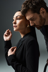 A loving couple, adorned in elegant attire, standing close together.