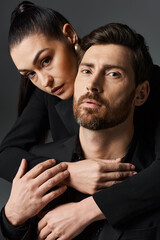 Elegant couple in love standing close, dressed stylishly.