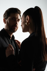 A stylish couple in elegant attire standing together with grace and affection.