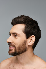 Obraz premium A bearded man stands shirtless, embodying strength and raw masculinity.