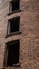 3 windows of an old, abandoned, brick tower