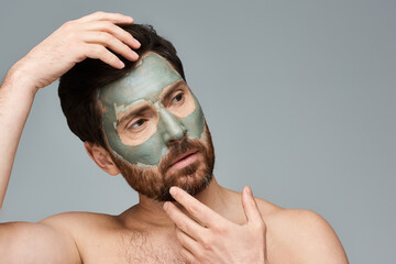 Handsome man applying a facial mask.